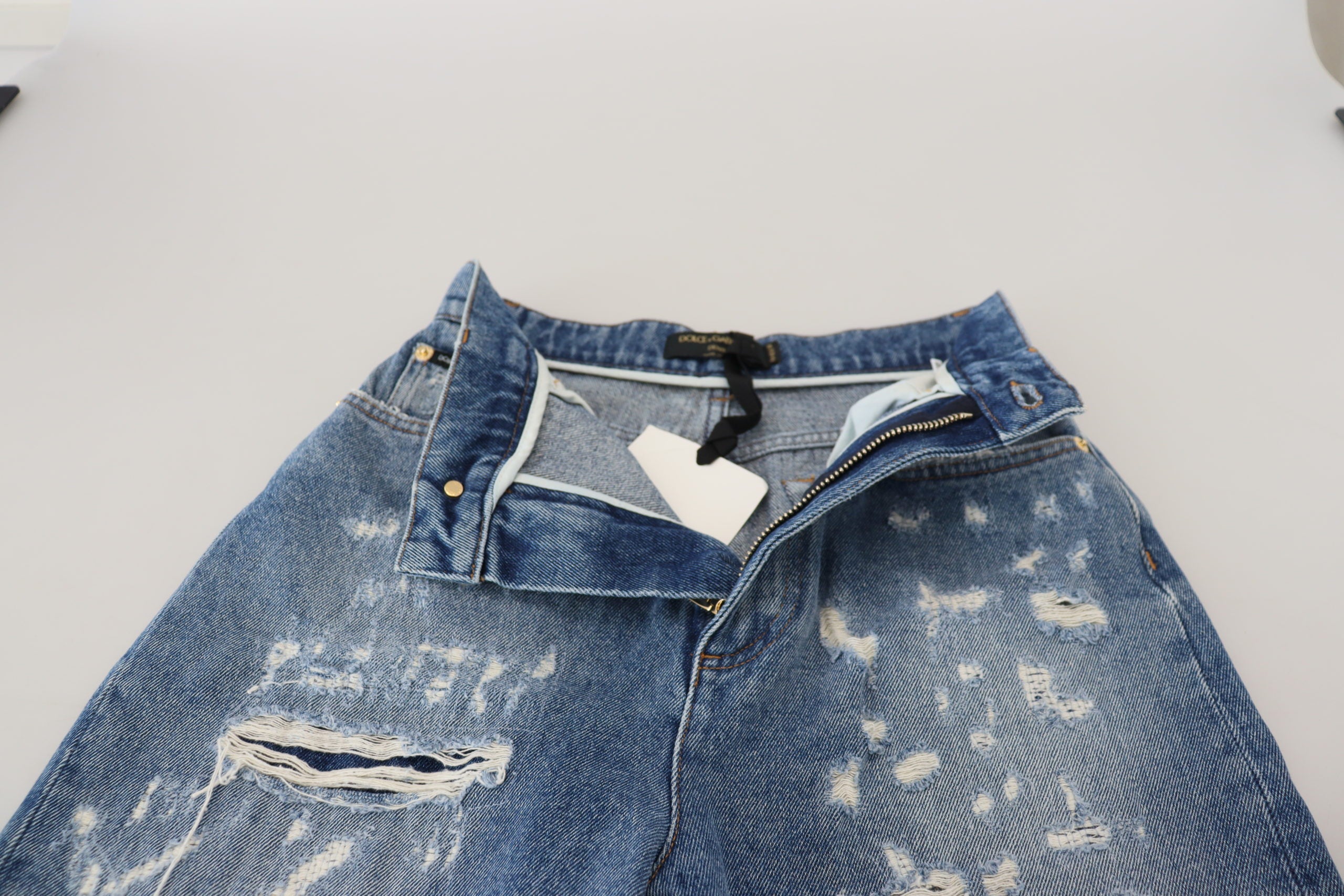 Blå tvättade bomulls-trasiga denimjeans