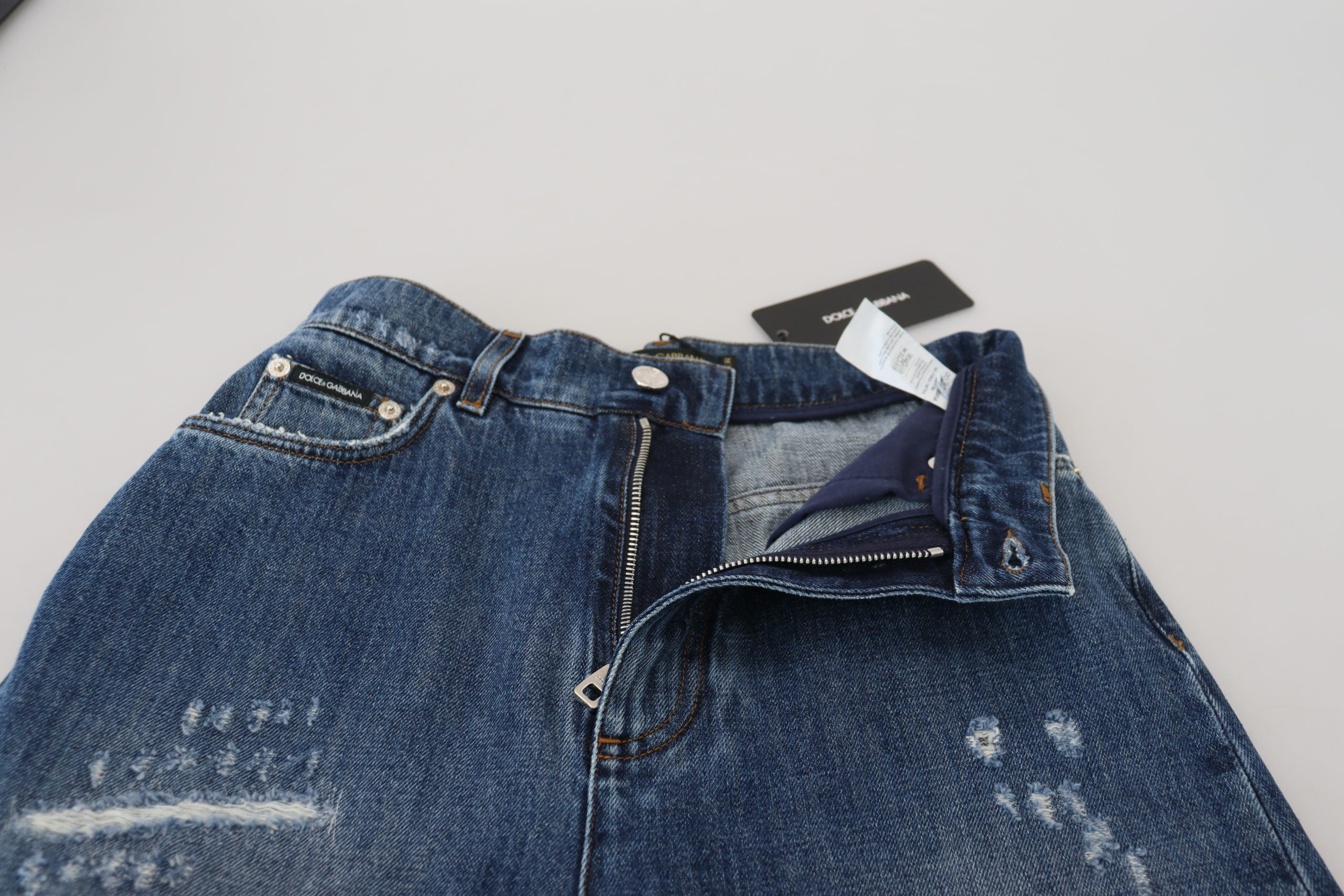 Blå tvättade bomulls-trasiga denimjeans