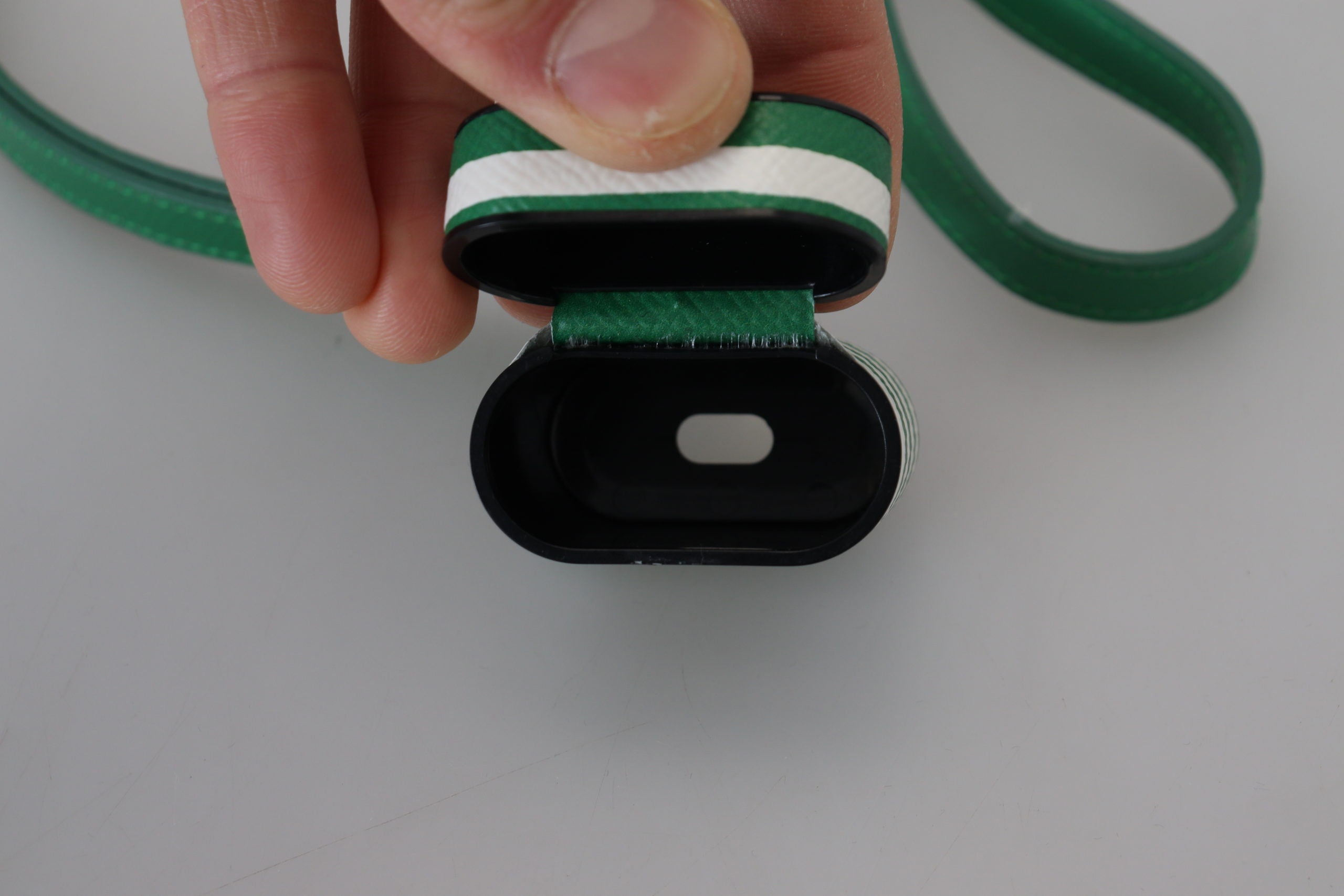 Grönt läderarmband med guldfärgad metalllogotyp för Airpods