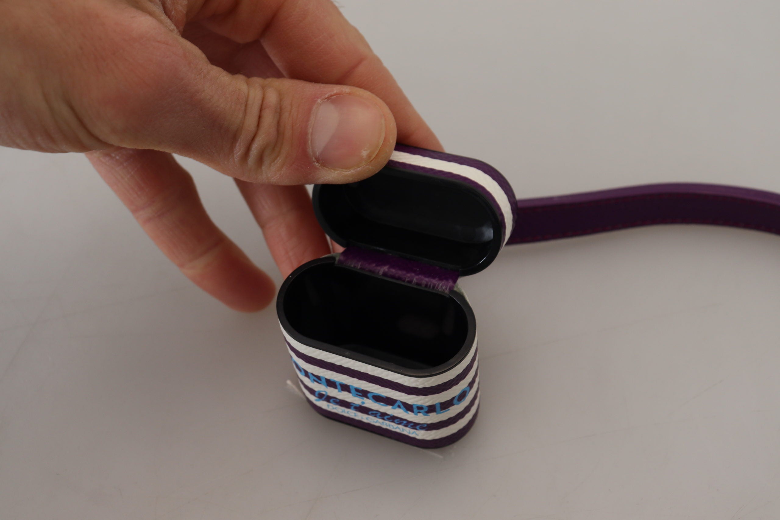 Lila läderrem med guldfärgad metalllogotyp för Airpods