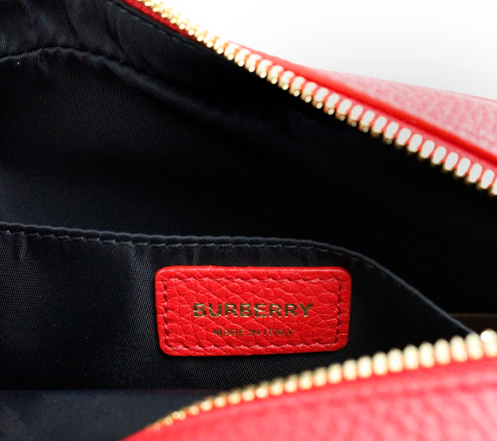 Liten, knallrød, kornete skinnveske med merkevarelogo og crossbody-design