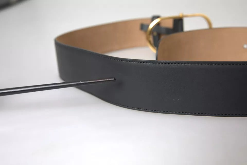 Svart skinnbelte med gullfarget oval metallspenne